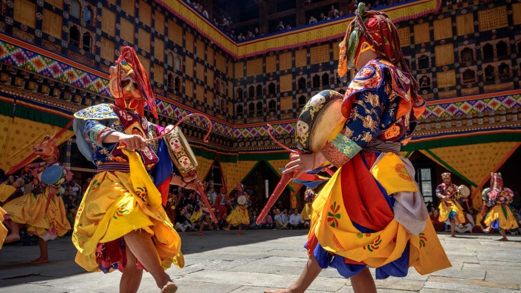 2 Monks dancing for colorful mask dance at yearly Paro Tsechu festival in Bhutan