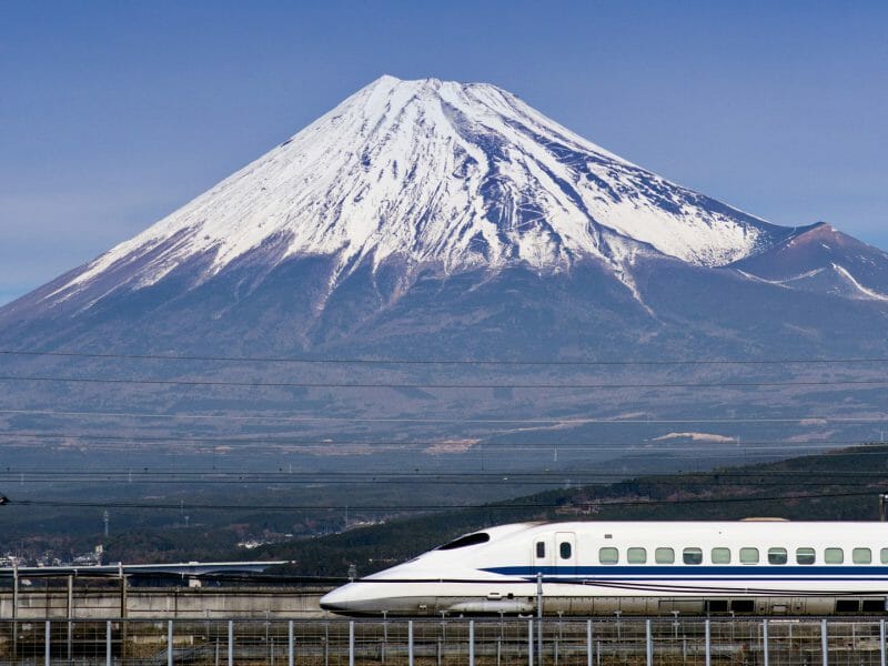 Bullet train passing infront of a snow capped Mount Fuji.