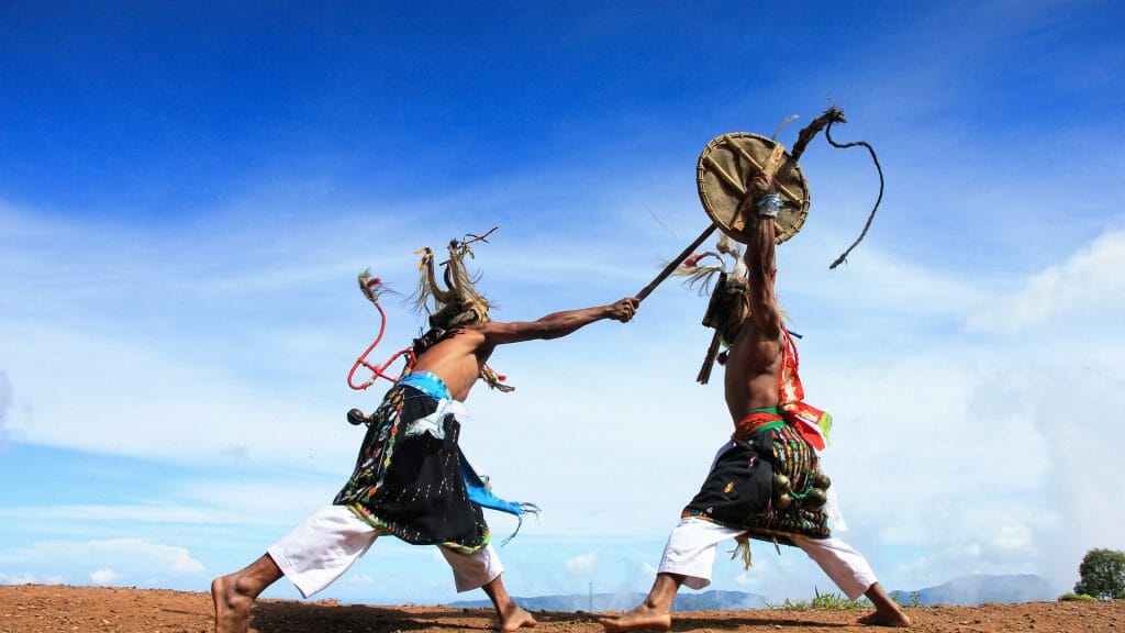 Two men engaged in a Caci dance, a traditional Indonesian dance from Labuan Bajo in Indonesia