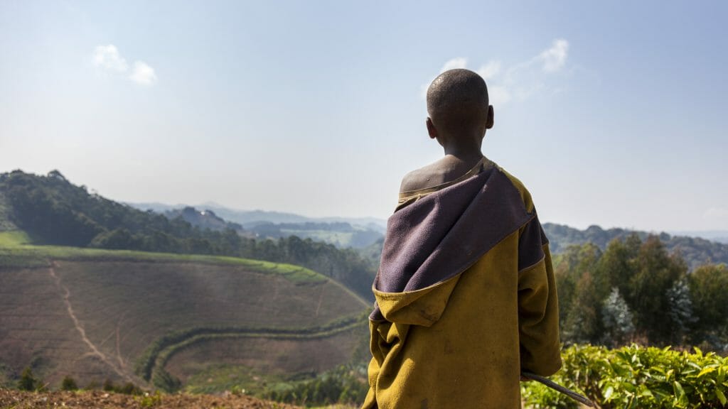 Child looking out over landscape, Rwanda