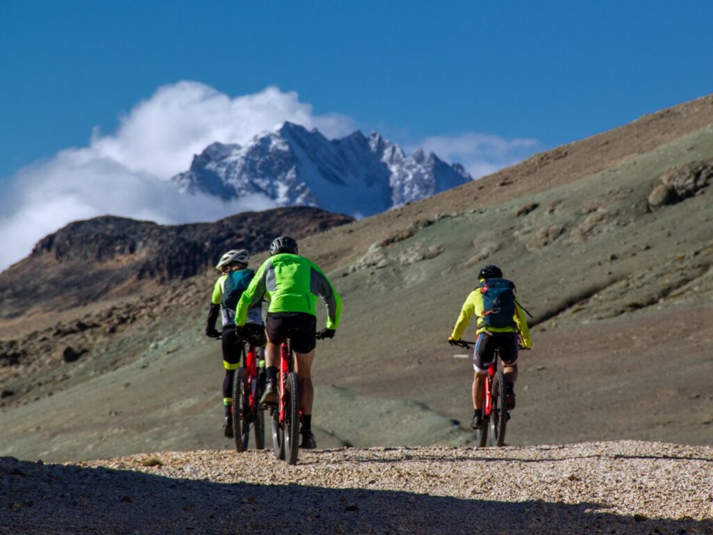 Three cyclists on dirt mountain track, Explora Patagonia National Park, Chile