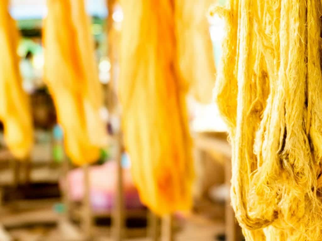 Close up of golden silk hanging to try.