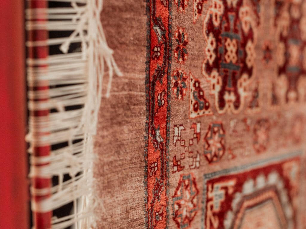 Full frame close up of patterned red carpet.