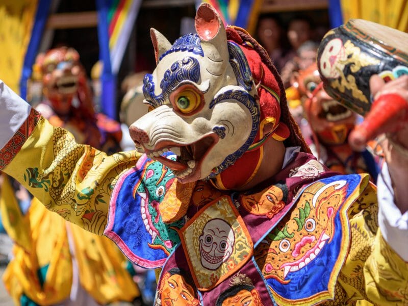 Monk enjoying his colorful mask dance at yearly Paro Tsechu festival in Bhutan, Paro, Bhutan