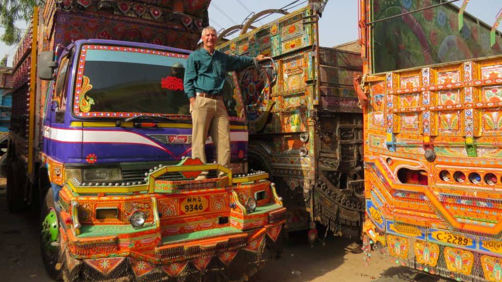 Paul stood on the bonnet of a brightly coloured, decorated Bedford truck.
