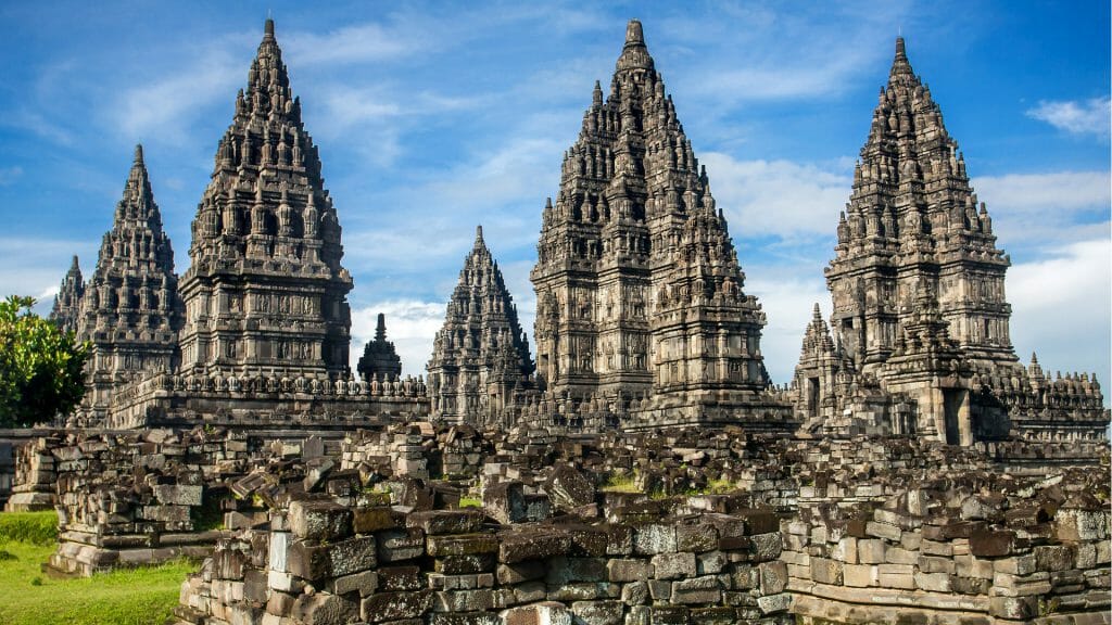 View of the spires of Prambanan Temple against blue sky.