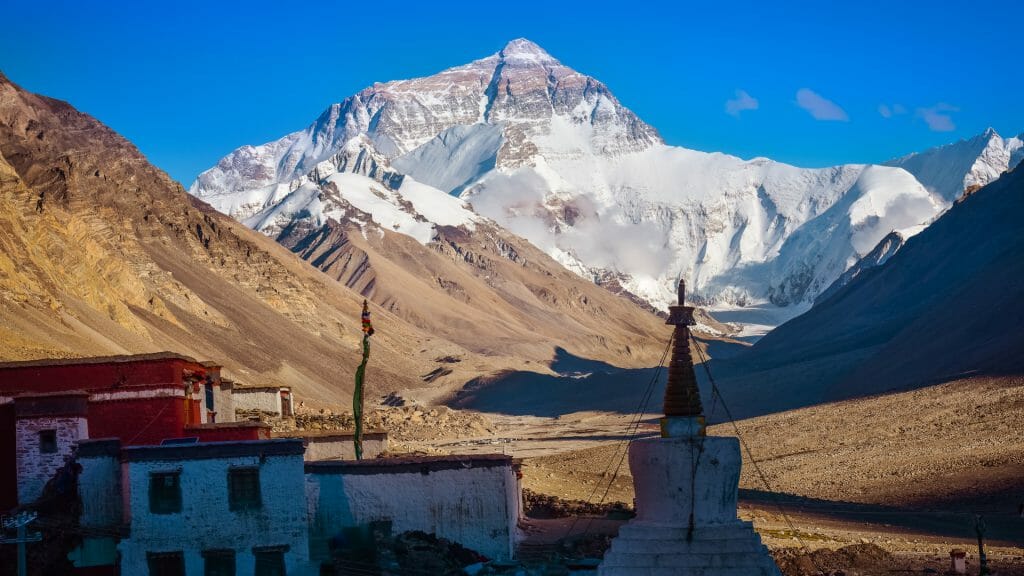 The spires of Rongbuk Monastery in the shadowy foreground with Mount Everest as its backdrop