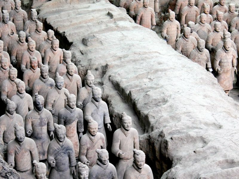 Lines of terracotta warriors stood in tomb trenches.