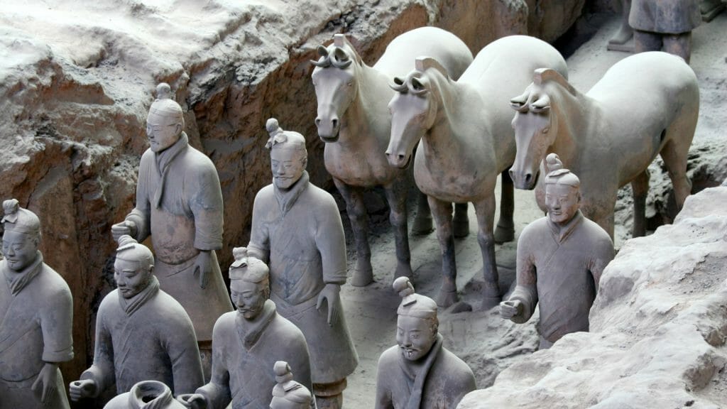 Terracotta soldiers and horses in a trench.