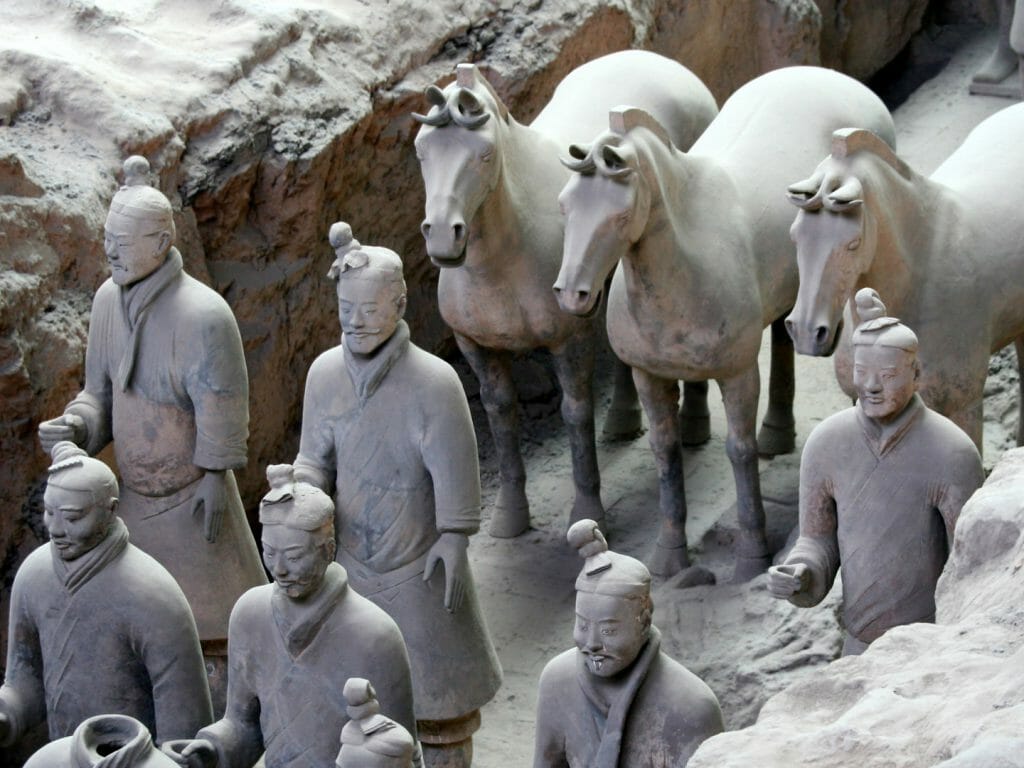 Terracotta soldiers and horses in a trench.