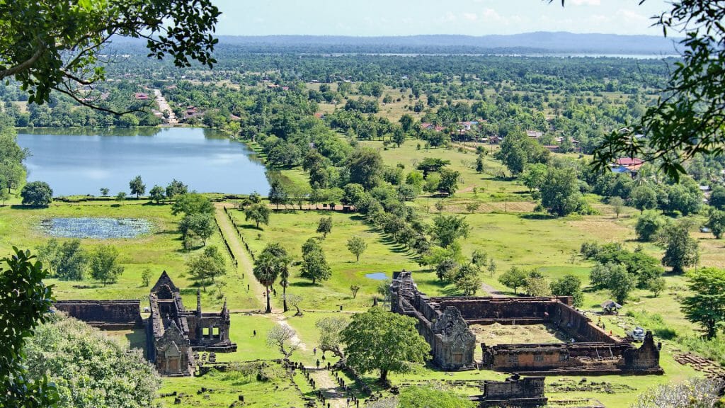 Aerial view of temple complex amid lush landscape.