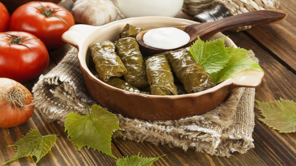 Dolma from grape leaves and minced on the wooden table, Greece