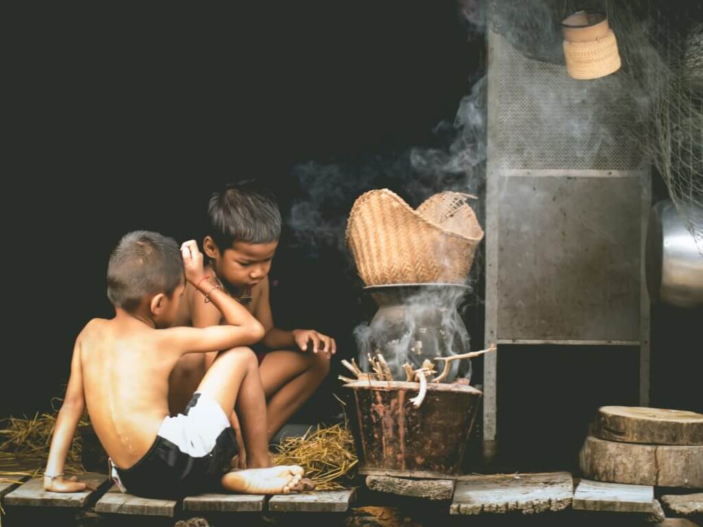 Children doing traditional fireside cooking in the countryside, Thailand