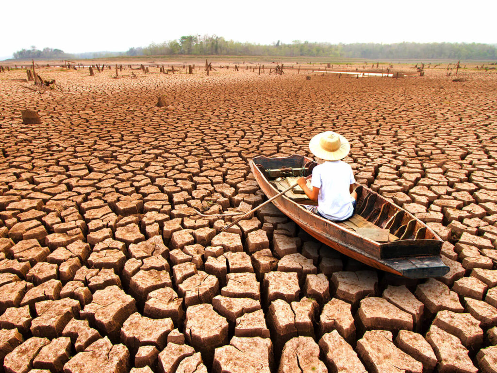 Man in boat on dried out lake