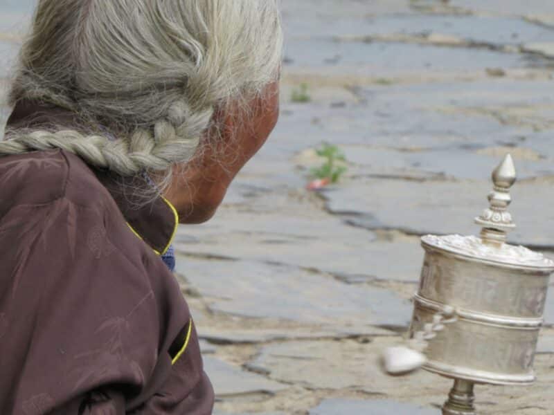 Tibetan woman with silver prayer wheel, Gansu Province, China