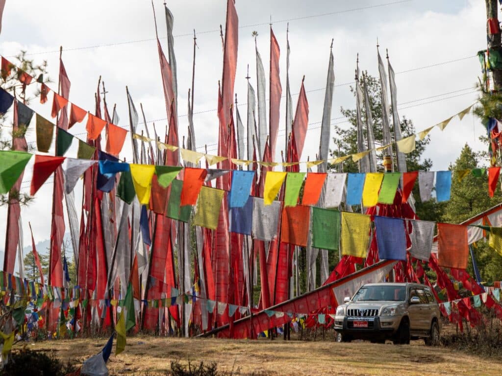 Car in prayer flags, near Gangtey. Bhutan