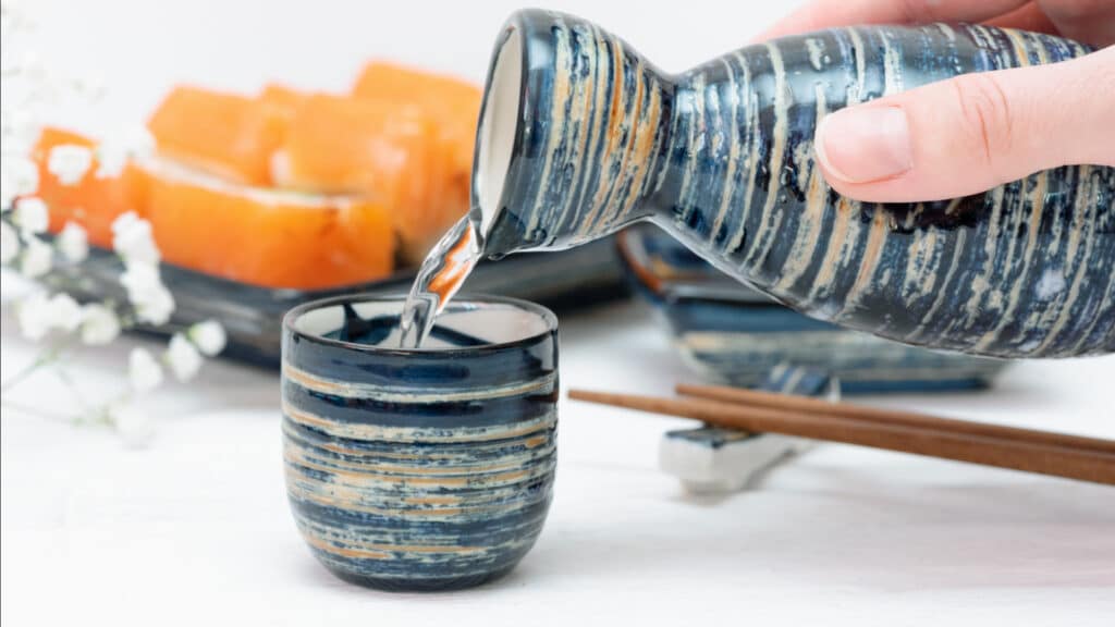 Pouring sake from bottle into cup