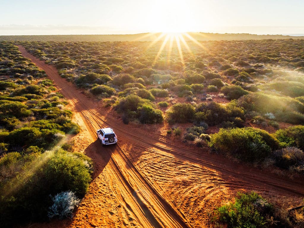 Australia, red sand unpaved road and 4x4 at sunset, Francoise Peron, Shark Bay