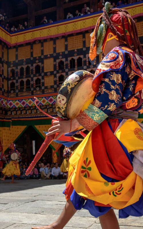 2 Monks dancing for colorful mask dance at yearly Paro Tsechu festival in Bhutan