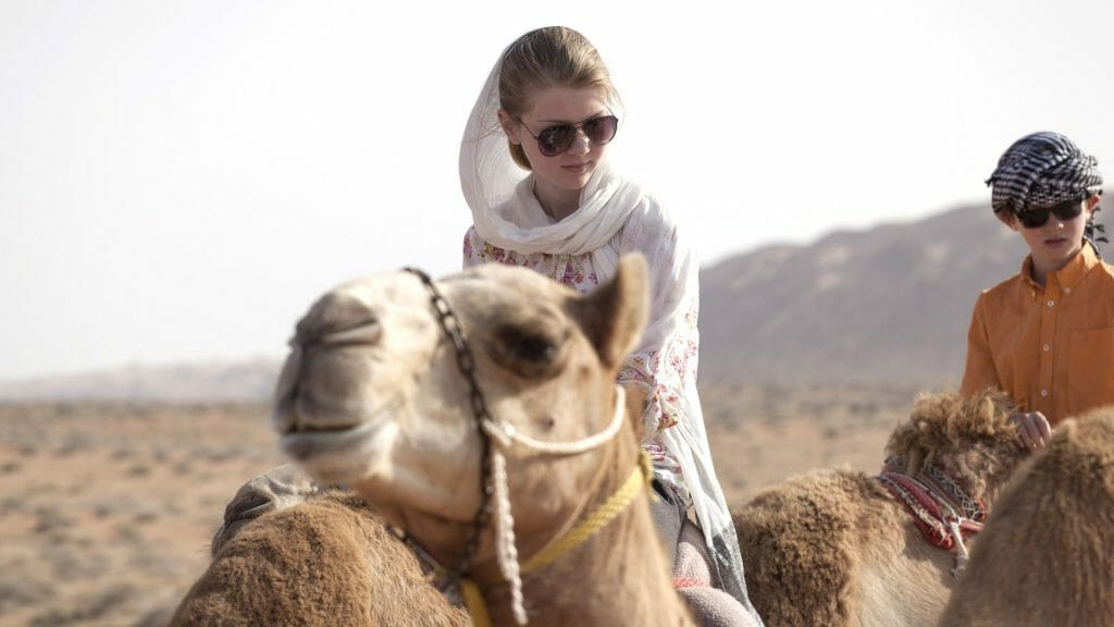Children riding camels, Oman