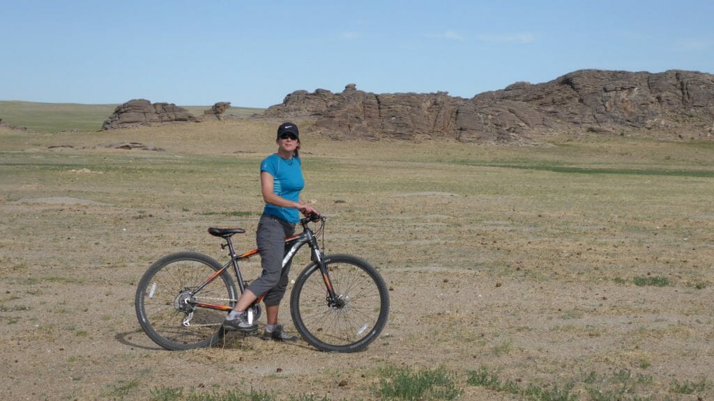 Lone cyclist on grass steppes of Mongolia.