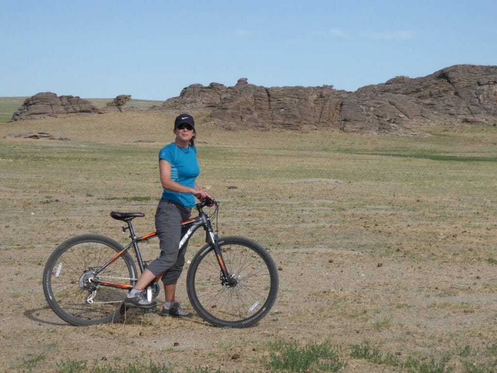 Lone cyclist on grass steppes of Mongolia.