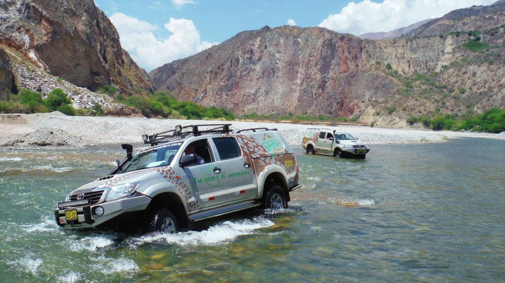 4x4 vehicles driving through river in Peru