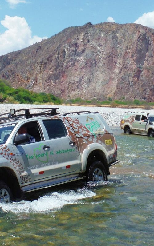 4x4 vehicles driving through river in Peru