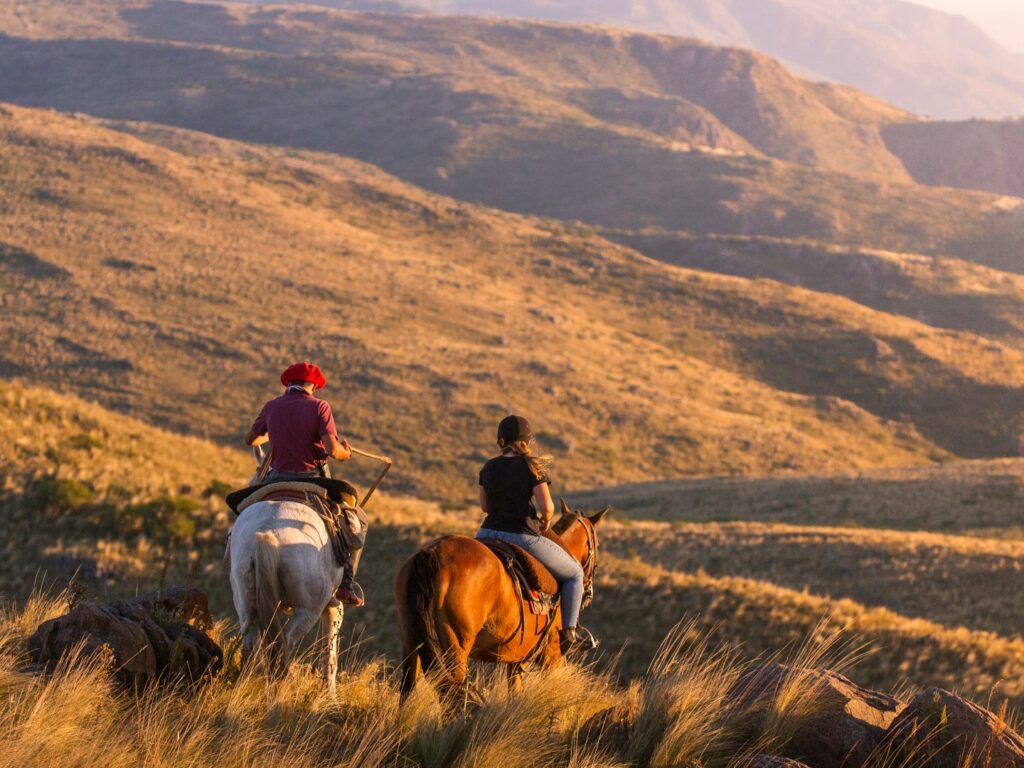 Two horse riders looking towards hills, Estancia Los Potreros, Cordoba, Argentina