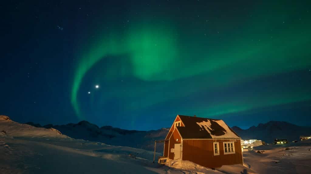 northern lights over a traditional wooden house, Greenland
