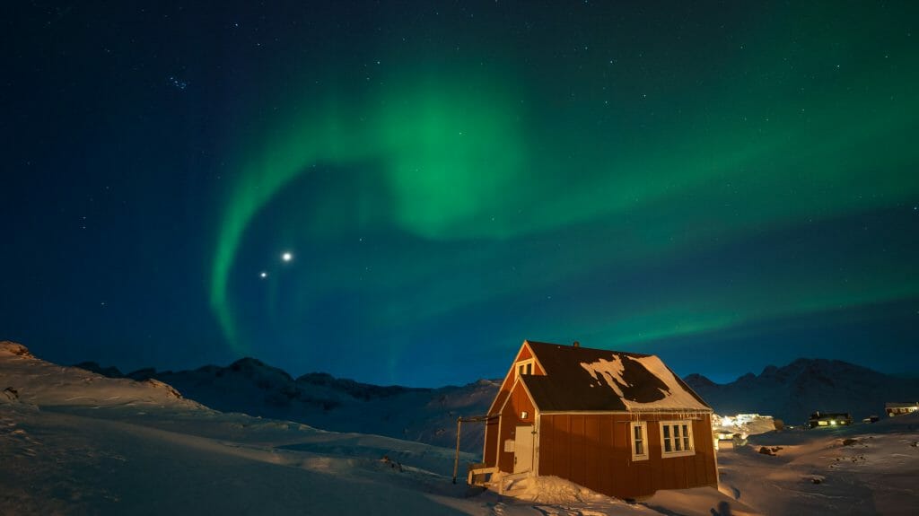 northern lights over a traditional wooden house, Greenland