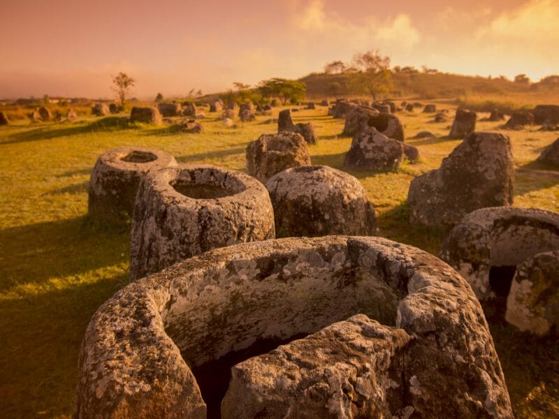 View of ancient jar shaped rocks covering a plain at sunrise.
