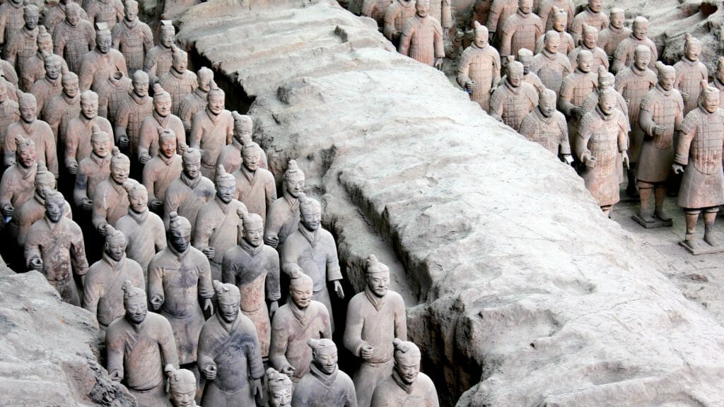 Lines of terracotta warriors stood in tomb trenches.