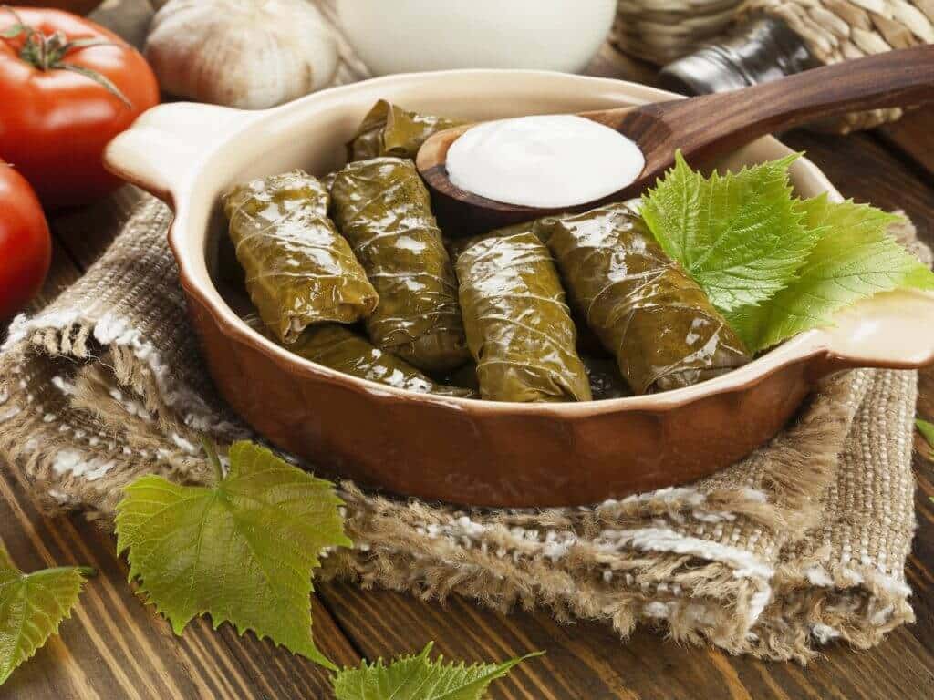 Dolma from grape leaves and minced on the wooden table, Greece