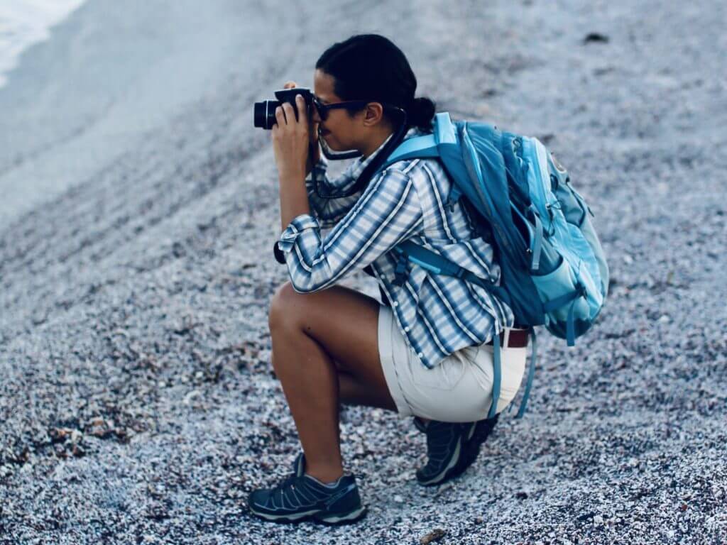 TV presenter and wild animal biologist Liz Bonnin taking photographs from a beach in the Galapagos Islands